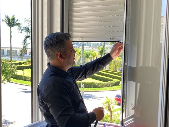 Técnico ajustando persiana externa integrada à esquadria